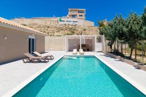 a swimming pool in the backyard of a house at Spartakos Luxury Villa 6 in Plános