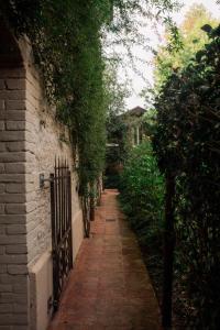 a brick alley with a fence and trees at Casale Hortensia in Reggio Emilia +24 photos