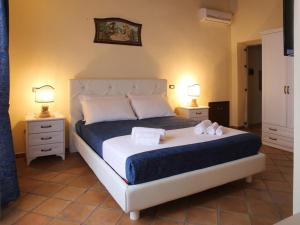 een slaapkamer met een bed met twee handdoeken erop bij Palazzo Madeo - Residenza d'Epoca in Crosia