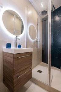 La salle de bains est pourvue d'un lavabo et d'une douche. dans l'établissement Audace - Magnifique Appartement 75m2 - Position Centrale Gare-Pompidou-Nouvelle Ville - Garage Privé - 2 à 4 Personnes, à Metz