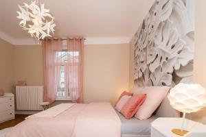 a bedroom with a white bed with pink pillows at Audace - Appartement Premium 75m2 avec parking privé - Centre de Metz - 2 à 4 Personnes in Metz