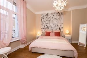 Un dormitorio con una cama grande y una lámpara de araña. en Audace - Magnifique Appartement 75m2 - Position Centrale Gare-Pompidou-Nouvelle Ville - Garage Privé - 2 à 4 Personnes en Metz
