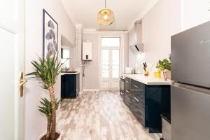 a kitchen with a palm tree in the middle of it at Audace - Appartement Premium 75m2 avec parking privé - Centre de Metz - 2 à 4 Personnes in Metz