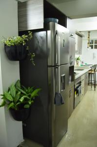 une cuisine avec un réfrigérateur en acier inoxydable et des plantes en pot dans l'établissement Acogedor apartamento en Itagui, à Itagüí