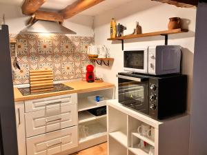 una cocina con encimera y horno microondas en MaderaVieja - Piscina & Jacuzzi, 