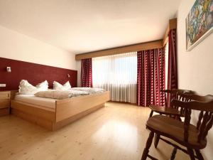 a bedroom with a bed and a large window at Ciasa de Zeno in La Valle