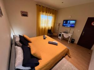 sypialnia z łóżkiem z pomarańczowym kocem w obiekcie Paradise w mieście Camarate