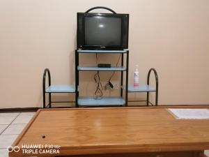 a tv sitting on a stand with a table at Kingsview 201 in Margate