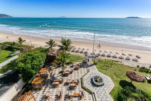 uma vista aérea de uma praia com cadeiras e do oceano em Ingleses Palace Hotel em Florianópolis