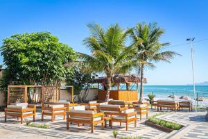 a beach with chairs and a gazebo and the ocean at Ingleses Palace Hotel in Florianópolis