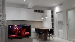 a kitchen with a tv and a table with chairs at RESIDENZA CORSO DALMAZIA in Civitanova Marche