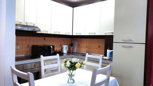 eine Küche mit einem Tisch und einer Blumenvase darauf in der Unterkunft Spacious family-friendly apartment in the heart of Bllok in Tirana
