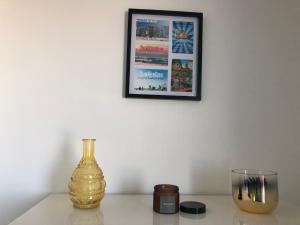 una mesa con un jarrón y una foto en la pared en Appartement sur la plage de Malo les bains vue mer, en Dunkerque