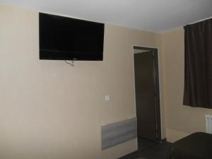 einen Flachbild-TV an der Wand eines Zimmers in der Unterkunft Hôtel La Tente Verte in Loon-Plage