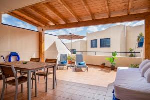 un patio avec une table, des chaises et un lit dans l'établissement El Rincón del Mar, à Lajita