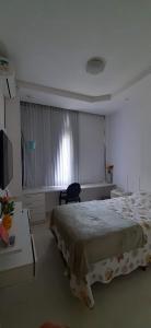 a bedroom with a bed and a desk and a window at Cantinho familiar-Humaitá - somente mulheres - just women in Rio de Janeiro