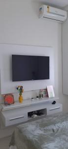a living room with a television on a white wall at Cantinho familiar-Humaitá - somente mulheres - just women in Rio de Janeiro