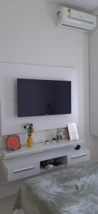 uma sala de estar com televisão numa parede branca em Cantinho familiar-Humaitá - somente mulheres - just women no Rio de Janeiro
