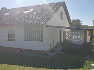 Biały dom z metalowym dachem w obiekcie Wohnung mit 2 Zimmern w mieście Ballenberg