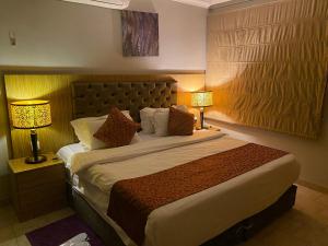 um quarto de hotel com uma cama grande com dois candeeiros em Garden City 2 em Riade