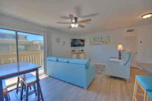 un soggiorno con divano blu e tavolo di Living the Dream 2 Bedroom Ocean View Cozy Condo a Gulf Shores
