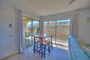 a living room with a couch and a table and a balcony at Living the Dream 2 Bedroom Ocean View Cozy Condo in Gulf Shores