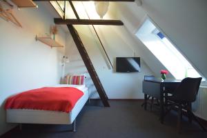 Billesgade Rooms في أودنسه: غرفة نوم مع سرير ومكتب في العلية