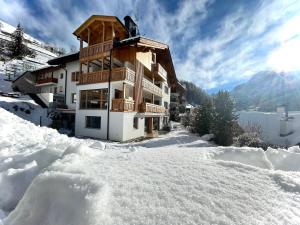 una casa en la nieve con nieve alrededor en Ciasa de Zeno, en La Valle