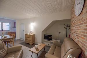 Vakantiewoningen Pomona في Heers: غرفة معيشة مع أريكة وجدار من الطوب