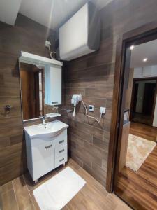 uma casa de banho com um lavatório branco e um espelho. em Apartmani Sorak Kopaonik, hotel Aris, Apartman A10 em Kopaonik