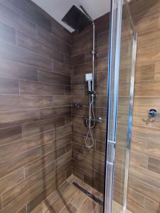 a bathroom with a shower with wooden tiles at Apartmani Sorak Kopaonik, Studio Apartman A10 in Kopaonik +16 photos