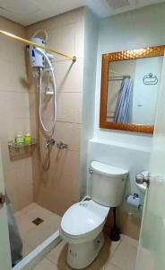 La salle de bains est pourvue de toilettes et d'une douche avec un miroir. dans l'établissement Love Marie, à Tagaytay