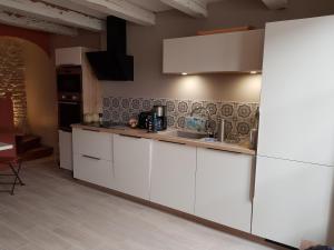 a kitchen with white cabinets and a sink at ilederesibois in Les Portes