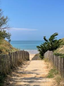 a dirt road next to a fence on a beach at ilederesibois in Les Portes