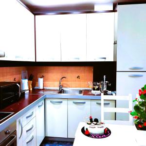 eine Küche mit weißen Schränken und einem Waschbecken in der Unterkunft Spacious family-friendly apartment in the heart of Bllok in Tirana