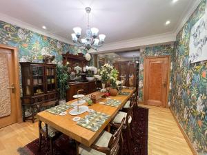 uma sala de jantar com uma grande mesa de madeira e papel de parede floral em Ailim House Serviced Cottage Escape, around the corner from the Old Course em St. Andrews
