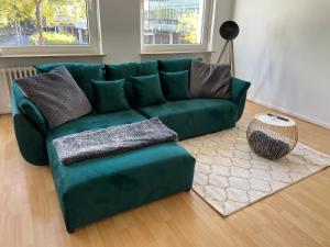 a green couch sitting in a living room at UrbanSuites - Stylish Apartments I Koblenz Center I Kitchen I up to 115m2 in Koblenz