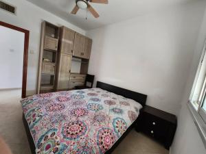1 dormitorio con 1 cama con un edredón colorido en Shturman Apartment Haifa, en Haifa