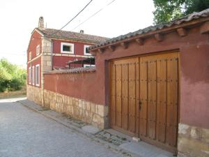 a red building with a large wooden garage door at Casa El Secretario in El Arenal