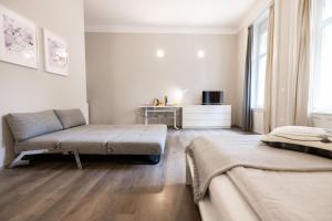 a white room with two beds and a couch at 4flats in Maribor