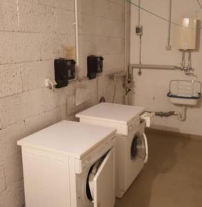 eine Waschküche mit Waschmaschine und Trockner in der Unterkunft Zimmer Hohbuch mit Achalmblick in Reutlingen