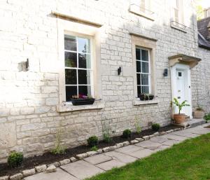 una casa in mattoni bianchi con due finestre e piante di Dream Stays Bath - Southbank, EVC Parking a Bath