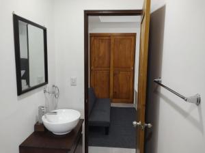 un bagno con lavandino, specchio e porta di Hakuna a San Juanillo