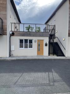 a white building with a staircase and a door at Lovely 4 bed apartment in centre of Formby in Formby