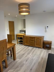 a kitchen with a table and a wooden cabinet at Lovely 4 bed apartment in centre of Formby in Formby