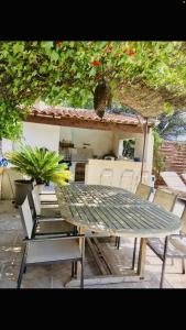 una mesa verde y sillas frente a una casa en Villa piscine 6km de Cassis 12 couchages, en Roquefort-la-Bédoule
