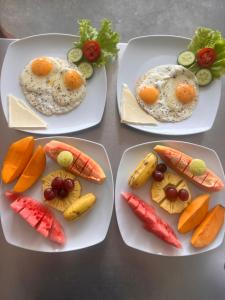 three plates of food with eggs and vegetables on a table at Top Secret Beach Hotel in Matara