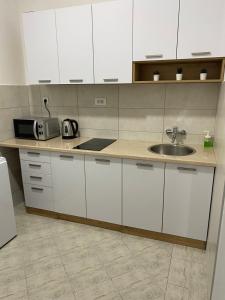 a kitchen with white cabinets and a sink at MAGIC M Apartment in Mali Mokri Lug