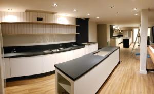 a kitchen with white cabinets and a black counter top at Hotel Praia Brava - Studios in Florianópolis