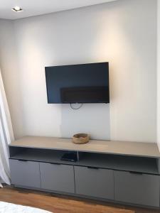 a flat screen tv on a white wall at Hotel Praia Brava - Studios in Florianópolis